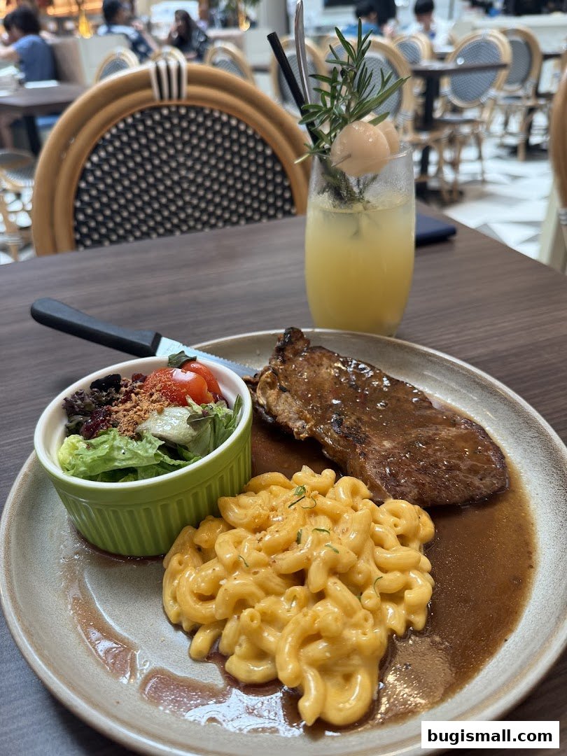 A plate of steak, macaroni and cheese, and a side salad with a refreshing drink.