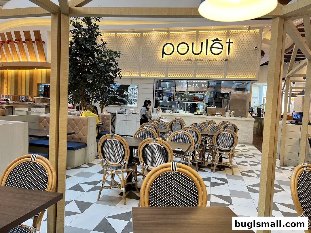 Interior of Poulet restaurant with tables, chairs, and kitchen visible.