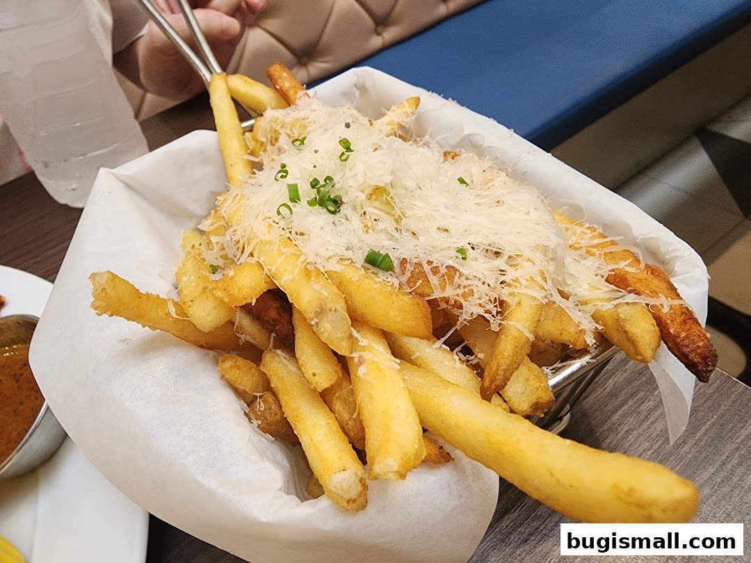 A basket of crispy french fries topped with grated cheese and chives.