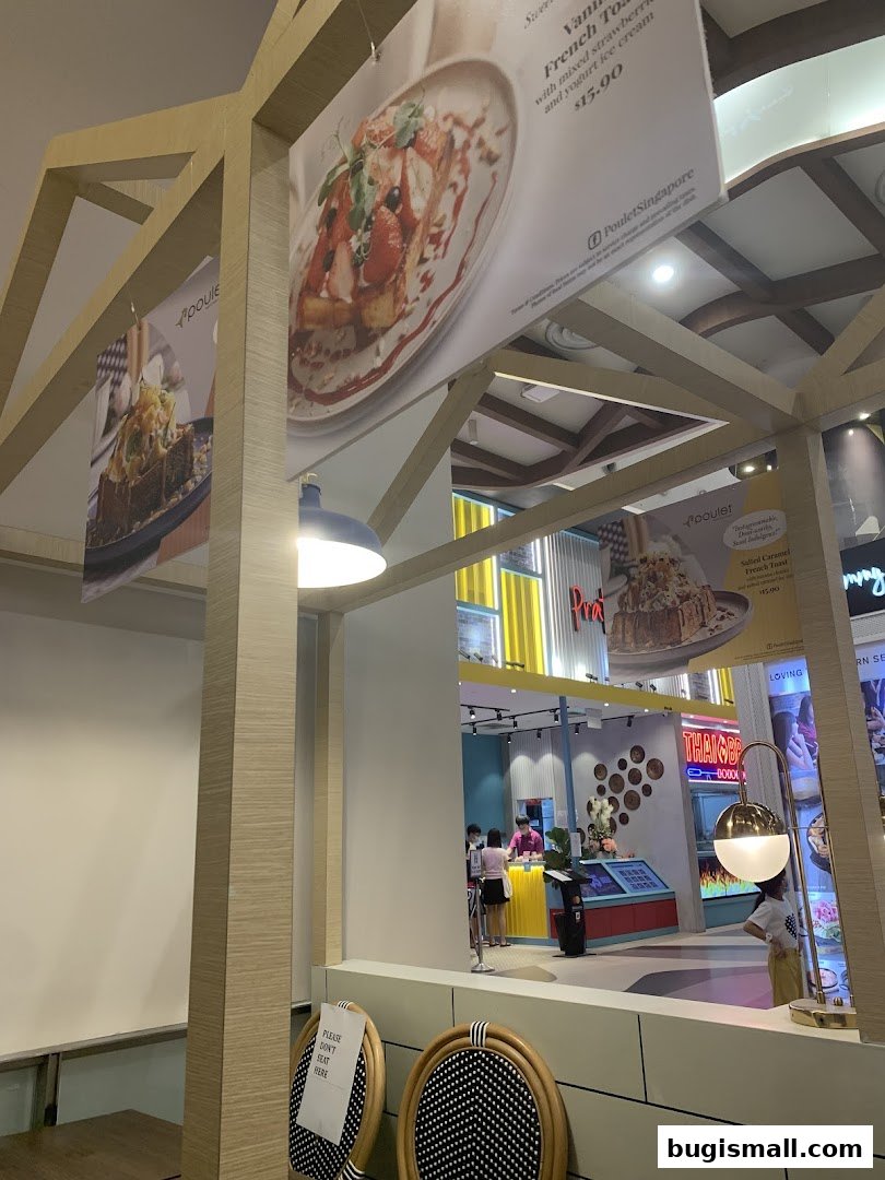 Interior view of Poulet restaurant with hanging menu boards and seating.