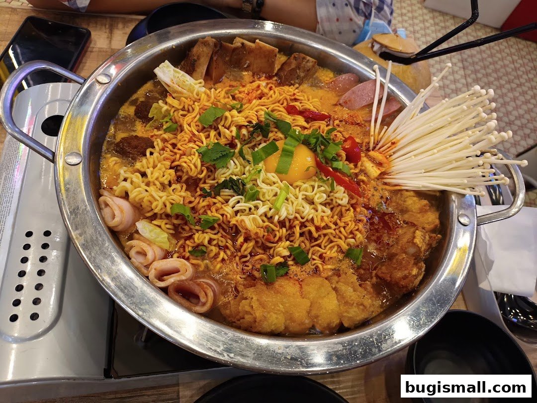 A steaming hot pot filled with noodles, enoki mushrooms, and various ingredients, ready to be enjoyed.