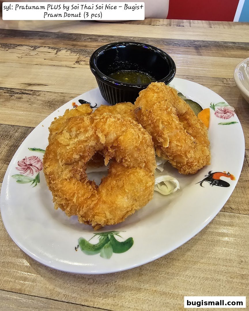 A plate of three crispy fried prawn donuts with a dipping sauce.