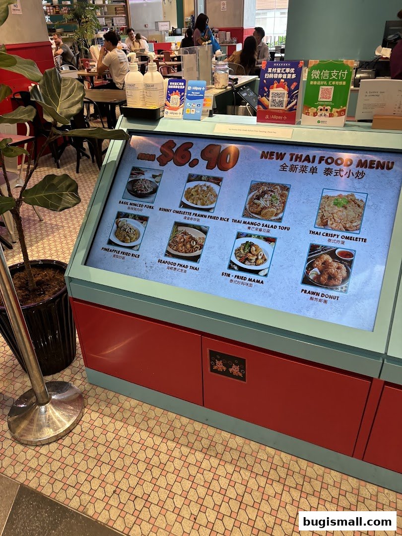 A digital menu board displaying various Thai food items with prices and images.