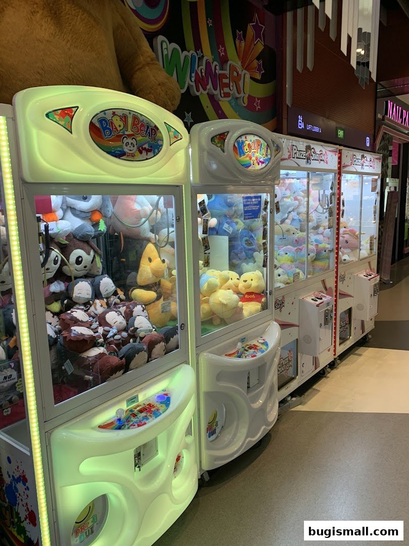 Prize Station claw machines filled with plush toys, with a large teddy bear in the background.