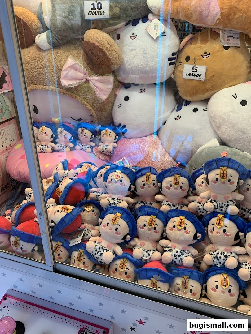 A claw machine filled with various plush toys, including cat-shaped and character plushies.