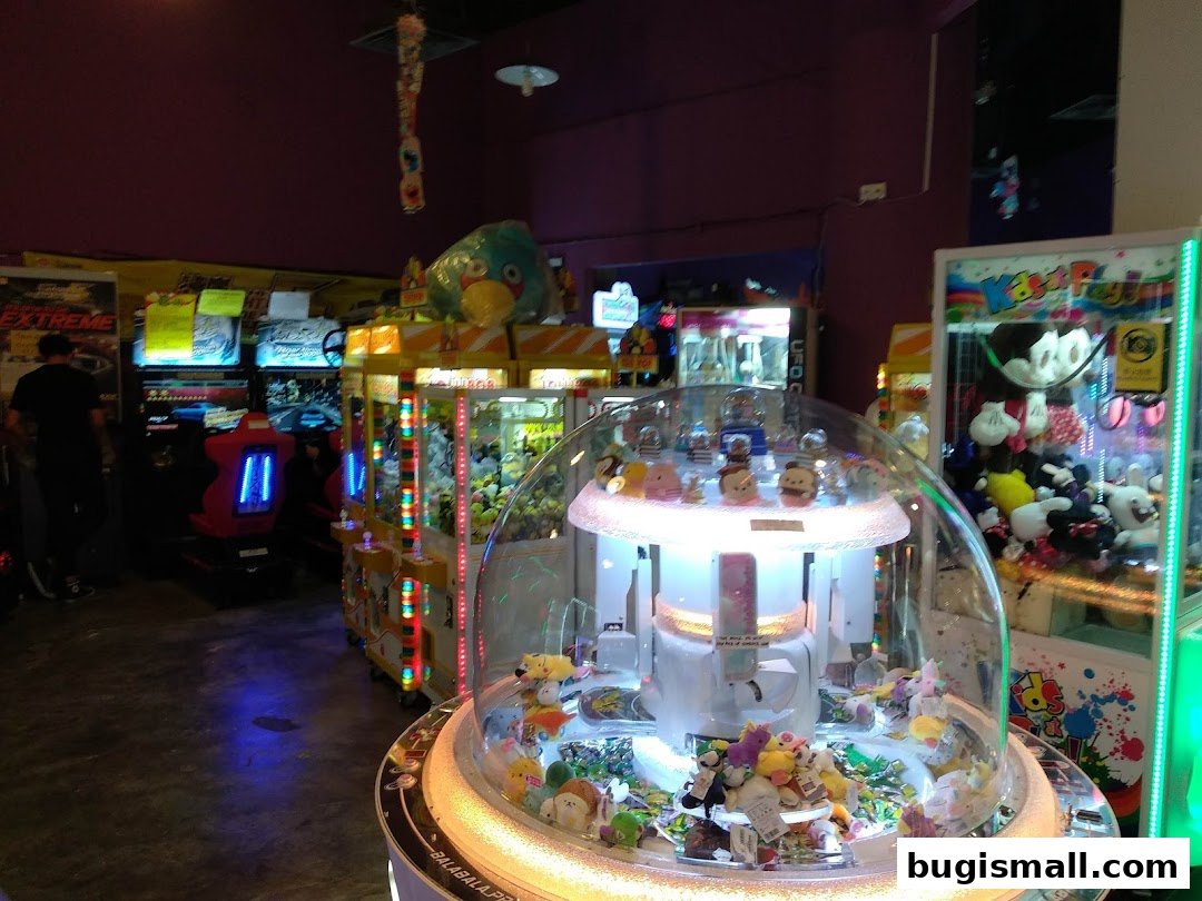 Interior of an arcade with various game machines and plush toys.