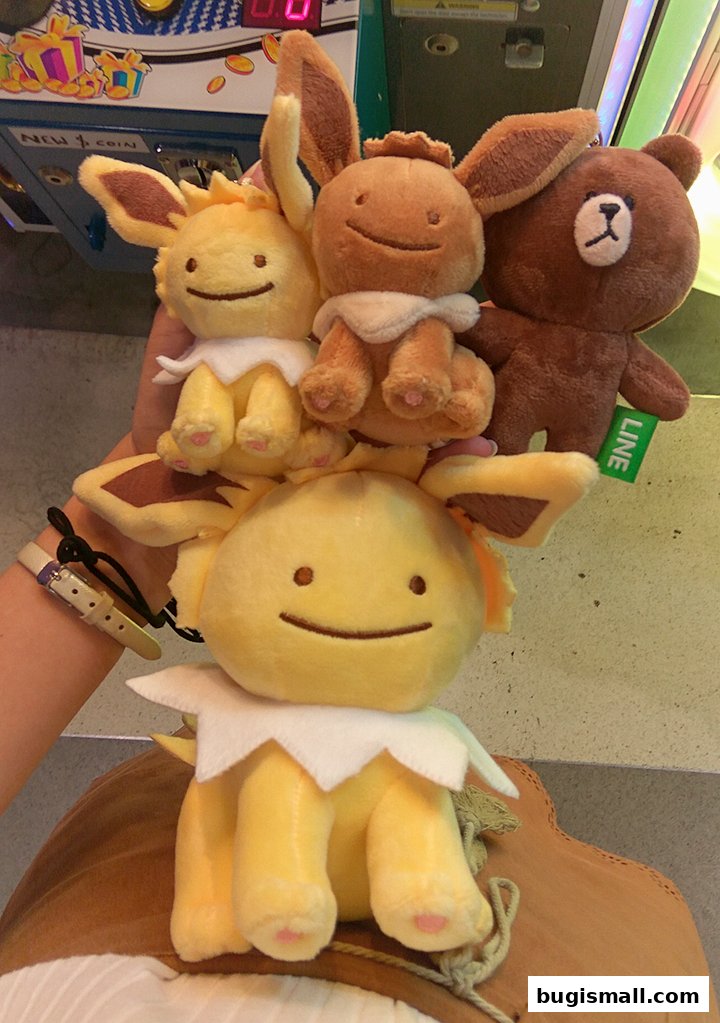 A person holds several plush toys, including characters resembling Pokemon and a LINE character.