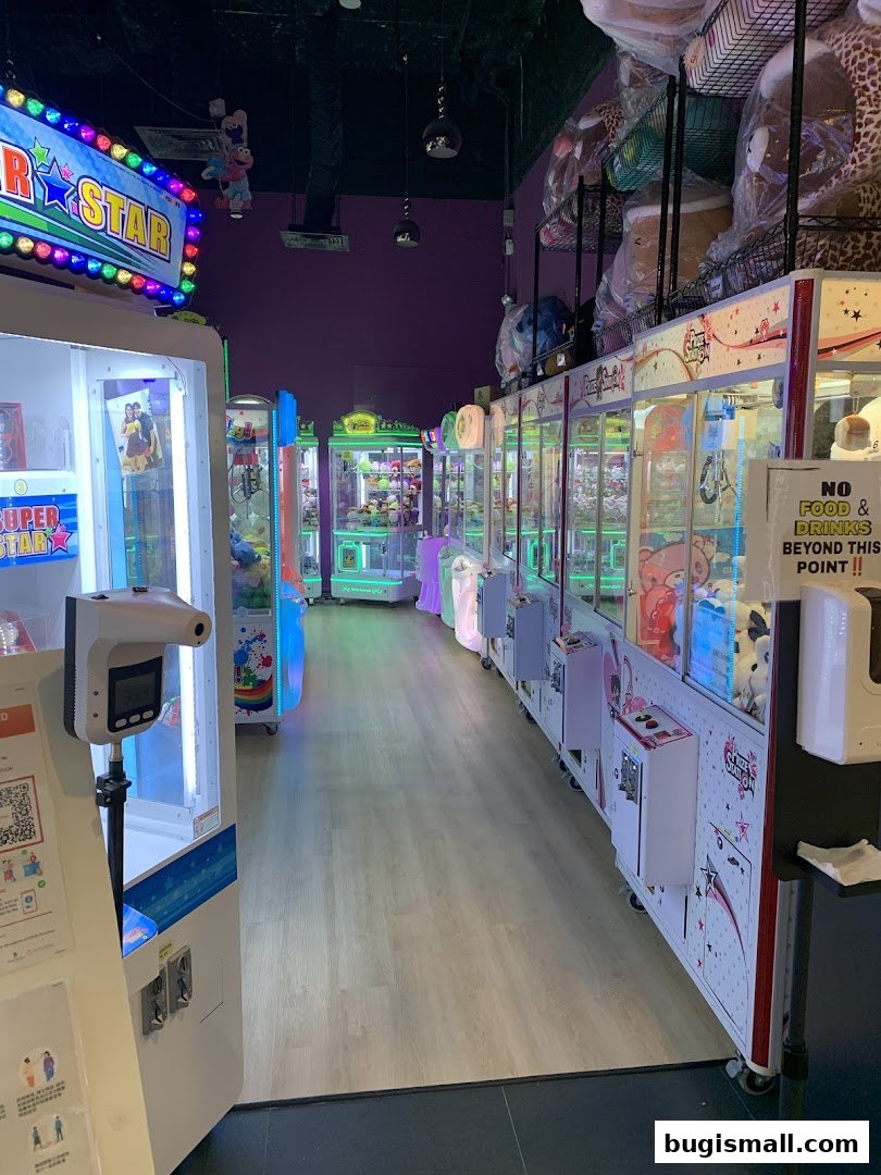 Interior view of Prize Station arcade with multiple claw machines filled with plush toys.