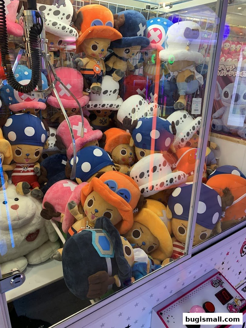 A claw machine filled with plush toys, many wearing hats.