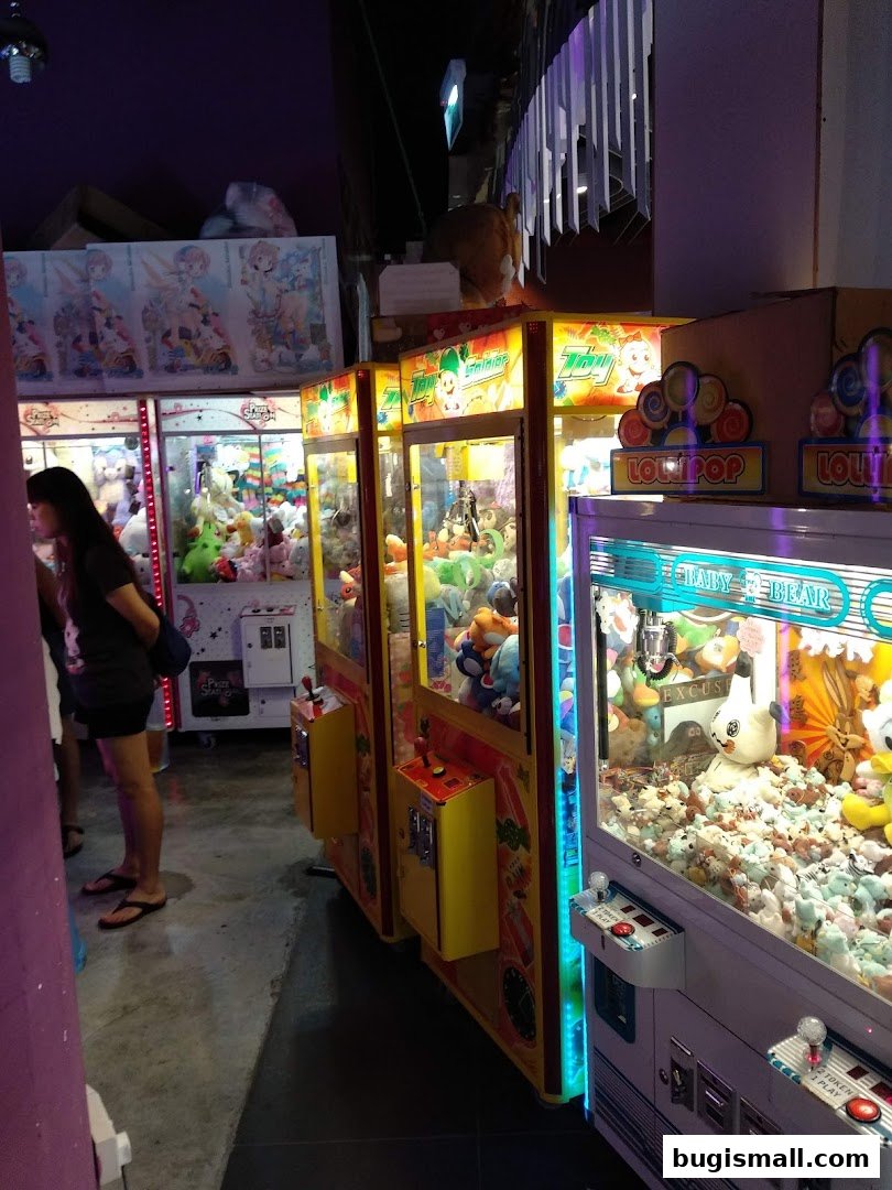 A row of colorful claw machines filled with plush toys, with a person looking at them.