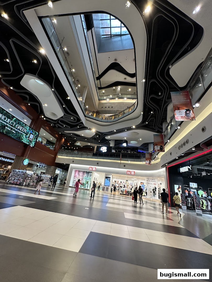 A wide shot of a modern shopping mall interior with a distinctive wavy ceiling design.