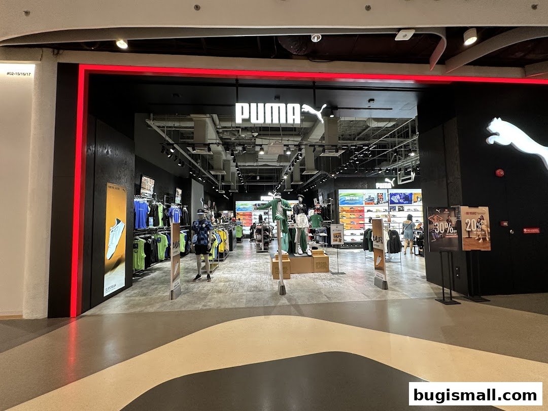 The entrance of a PUMA store showcasing apparel, footwear, and promotional displays.