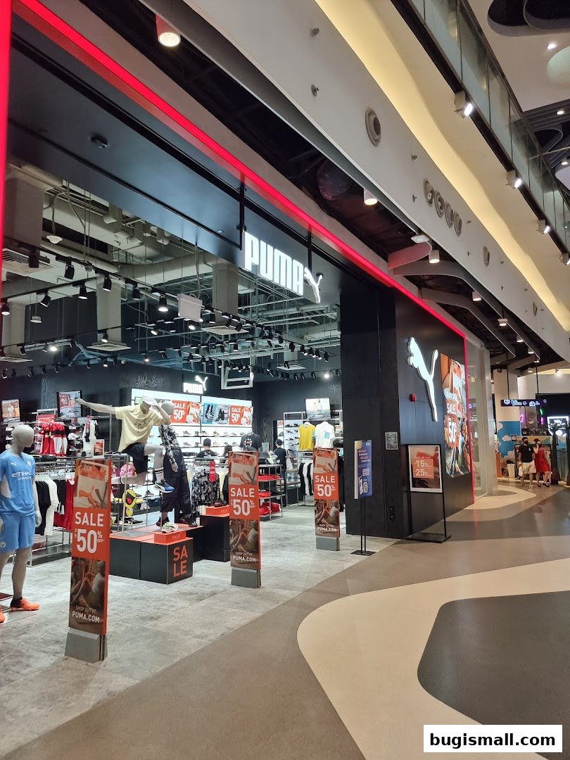 The PUMA Bugis store features a modern facade with prominent branding and sale displays.