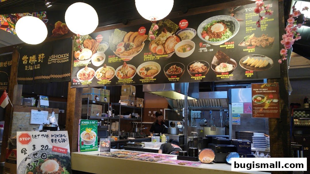 A ramen shop counter with a menu board displaying various ramen dishes and side items.