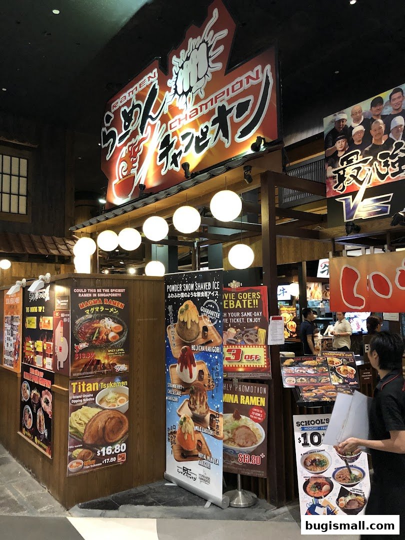 Ramen Champion shop with various food posters and a staff member holding a menu.