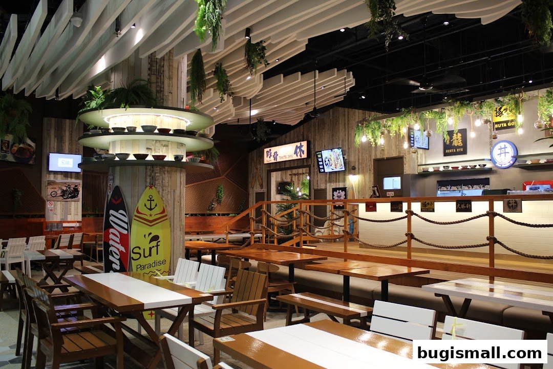 Interior view of a ramen restaurant with wooden tables, chairs, and surf-themed decor.