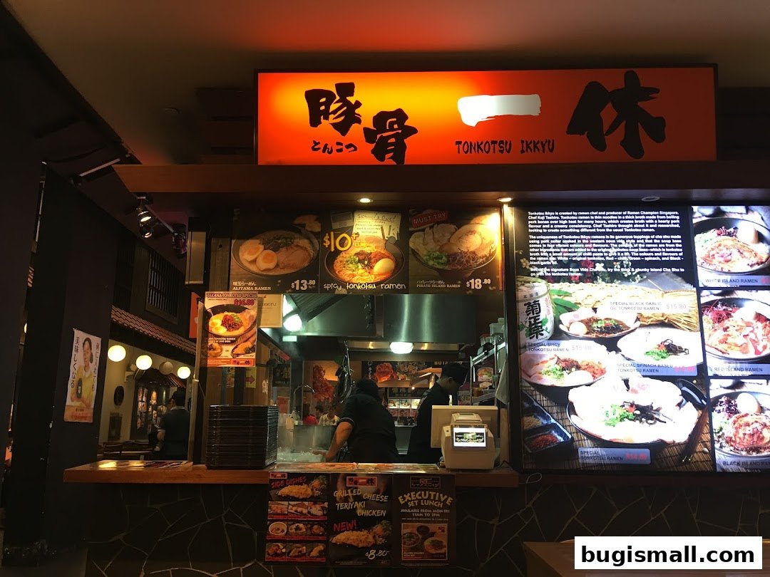 A ramen shop counter with various ramen dishes displayed on a digital menu board.