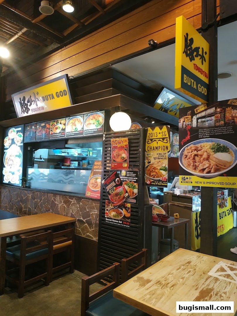 Interior of a ramen shop with tables, chairs, and menu displays.