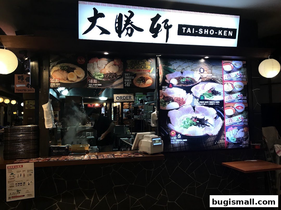 A ramen shop counter with a menu display showing various ramen dishes and prices.