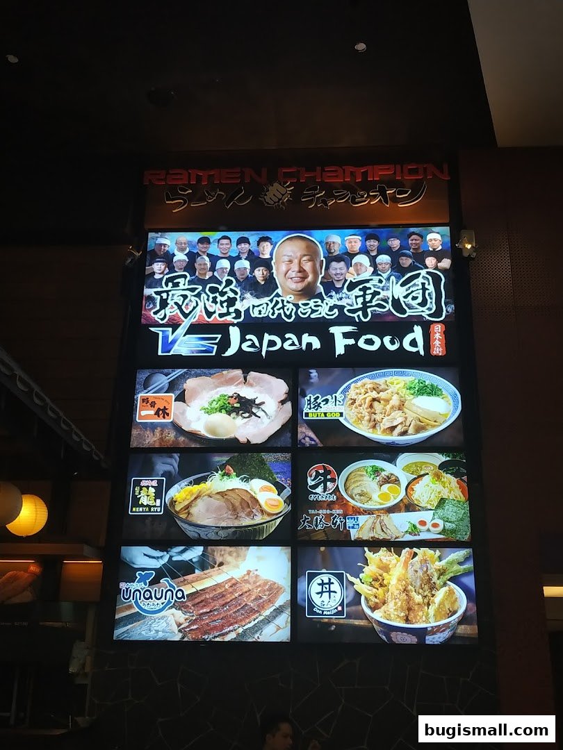 A large illuminated sign for Ramen Champion displaying various ramen dishes and Japanese food.