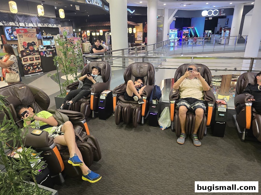 People relaxing in massage chairs in a shopping mall, some looking at their phones.
