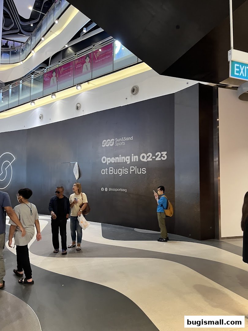 A wall display announcing the opening of Sun & Sand Sports at Bugis Plus.