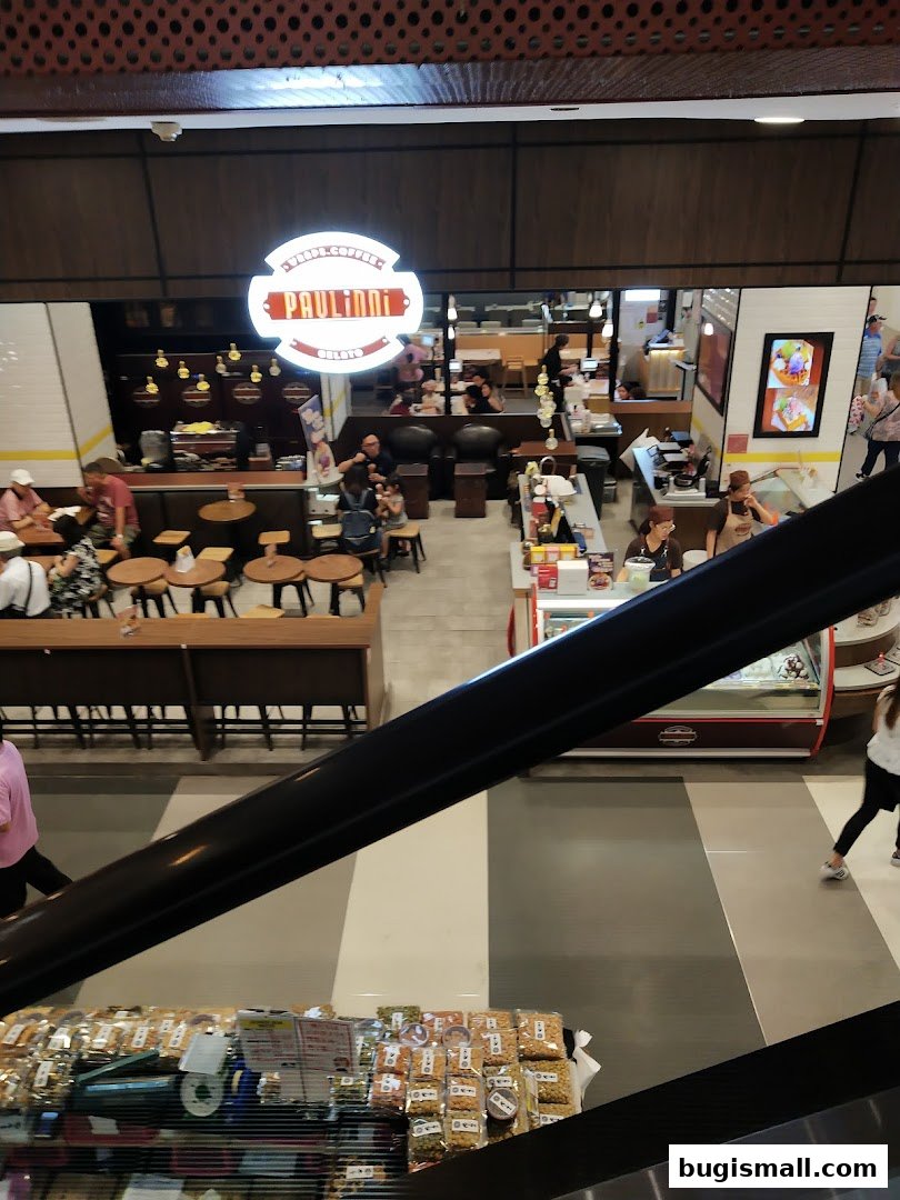 A view of a cafe and gelato shop with customers and seating areas.