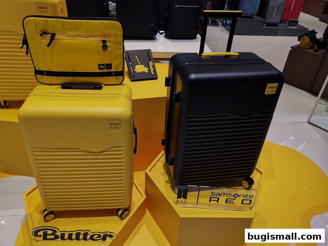 Yellow and black luggage displayed on yellow stands, with a laptop bag on top.