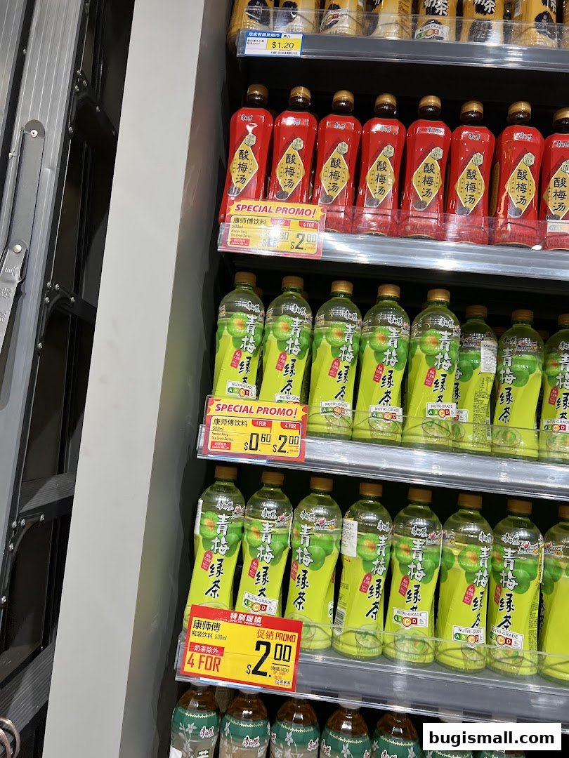 Shelves stocked with bottled drinks, featuring red bottles of plum juice and green bottles of green tea.