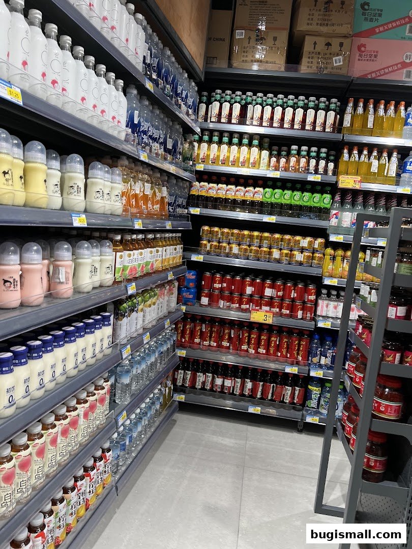 A wide aisle in a supermarket stocked with various beverages and bottled goods.