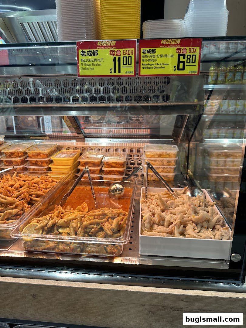A display case filled with various types of prepared chicken feet, some with sauce and lemon slices.