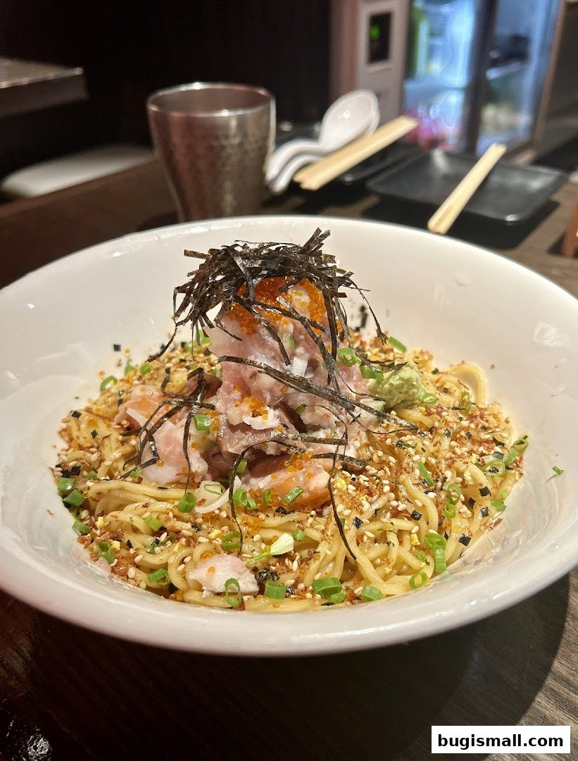 A bowl of ramen with tuna, roe, seaweed, and green onions.