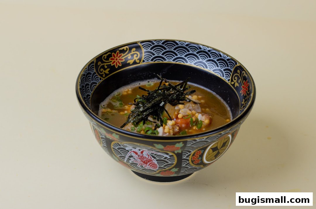 A close-up shot of a beautifully decorated bowl of scrambled egg rice with nori and green onions.