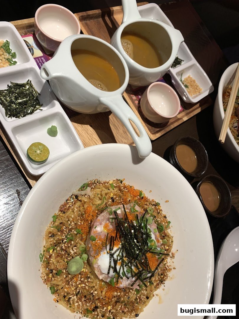 A close-up of a delicious bowl of noodles with a poached egg and various toppings.