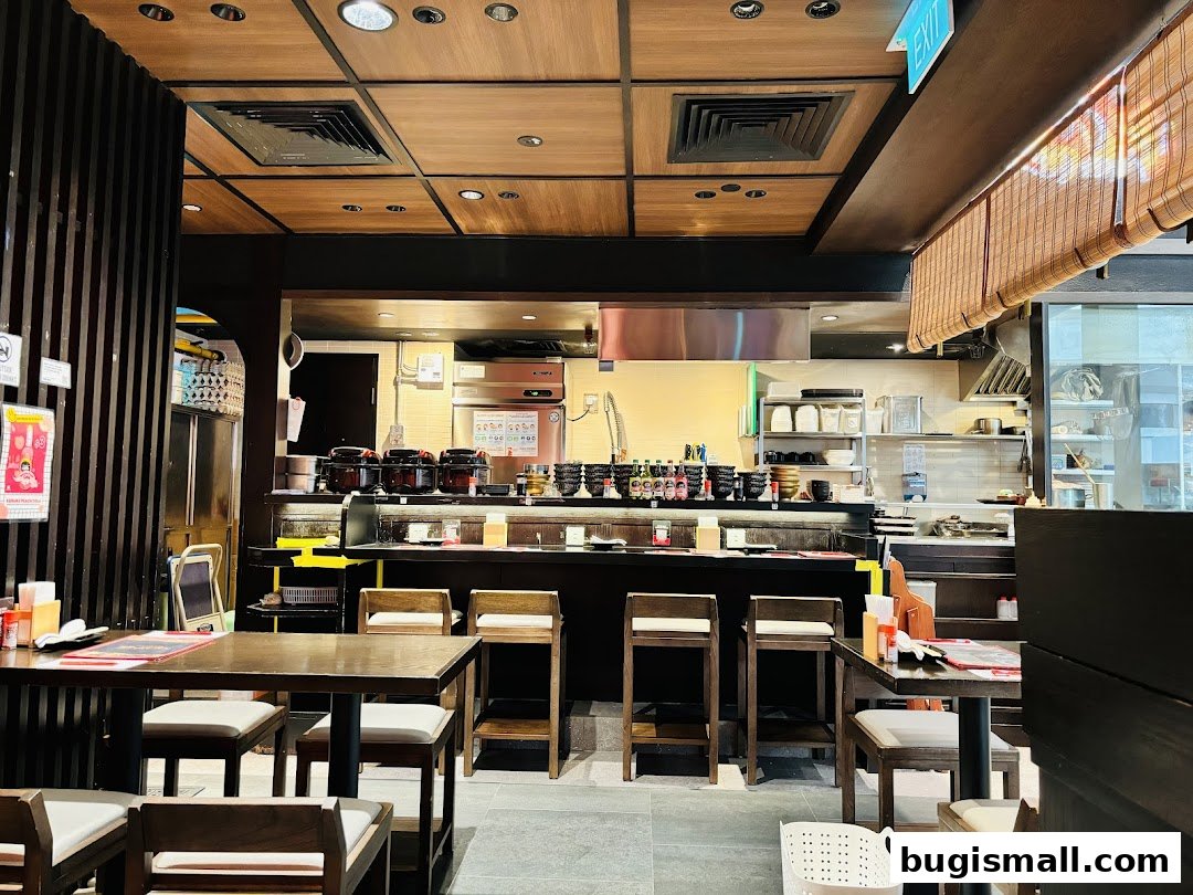 Interior view of a Japanese restaurant with wooden tables, chairs, and a counter.