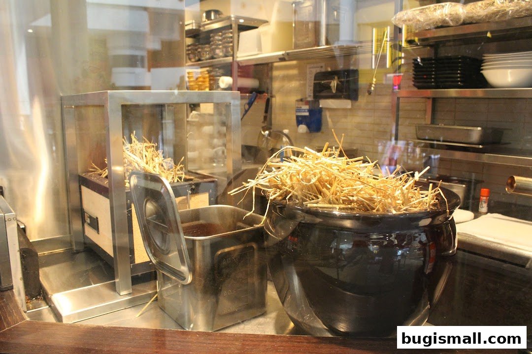 A close-up view of a restaurant kitchen with straw in a pot and cooking equipment.