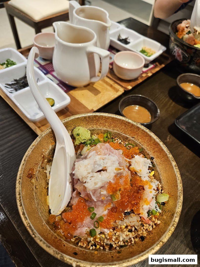 A close-up of a delicious bowl of scrambled egg rice with toppings and side dishes.