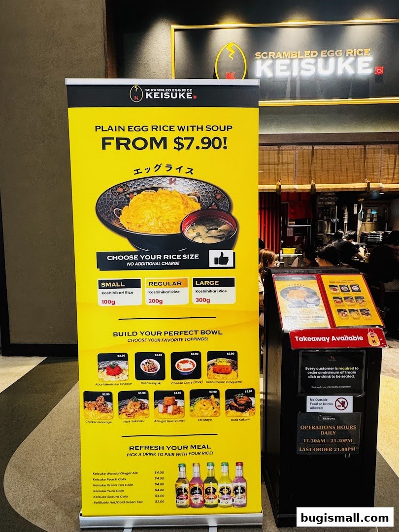 A promotional stand for Scrambled Egg Rice Keisuke, showcasing their signature dish and customizable toppings.