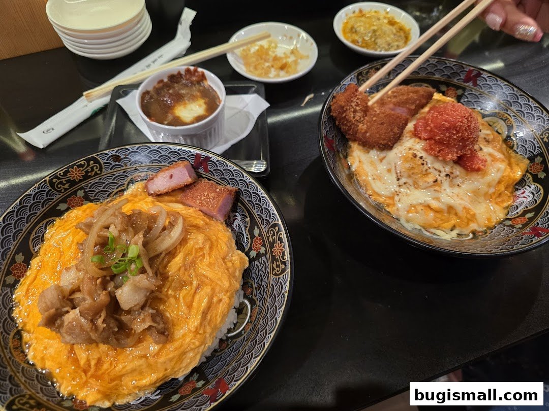 Two delicious bowls of scrambled egg rice with various toppings and a side dish.
