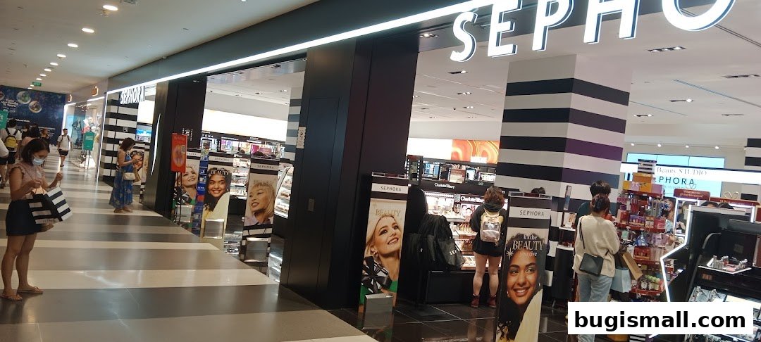 The entrance of a Sephora store with customers browsing beauty products and displays.