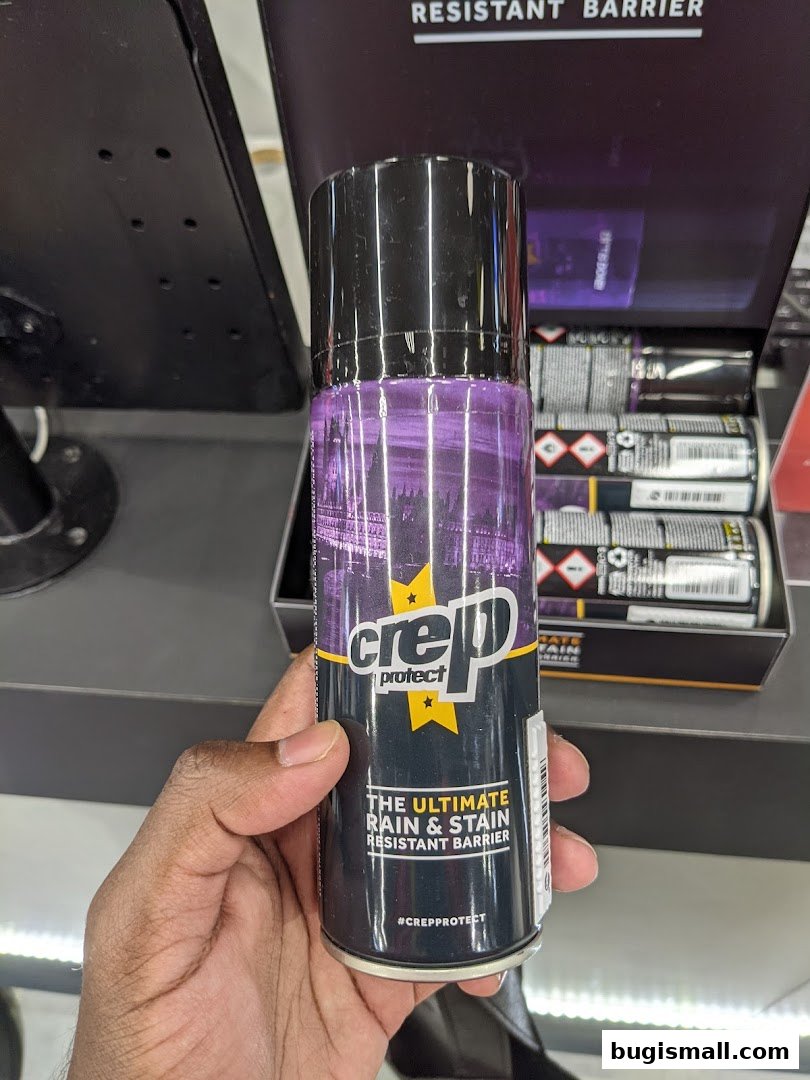 A hand holds a can of Crep Protect spray, advertising a rain and stain resistant barrier.