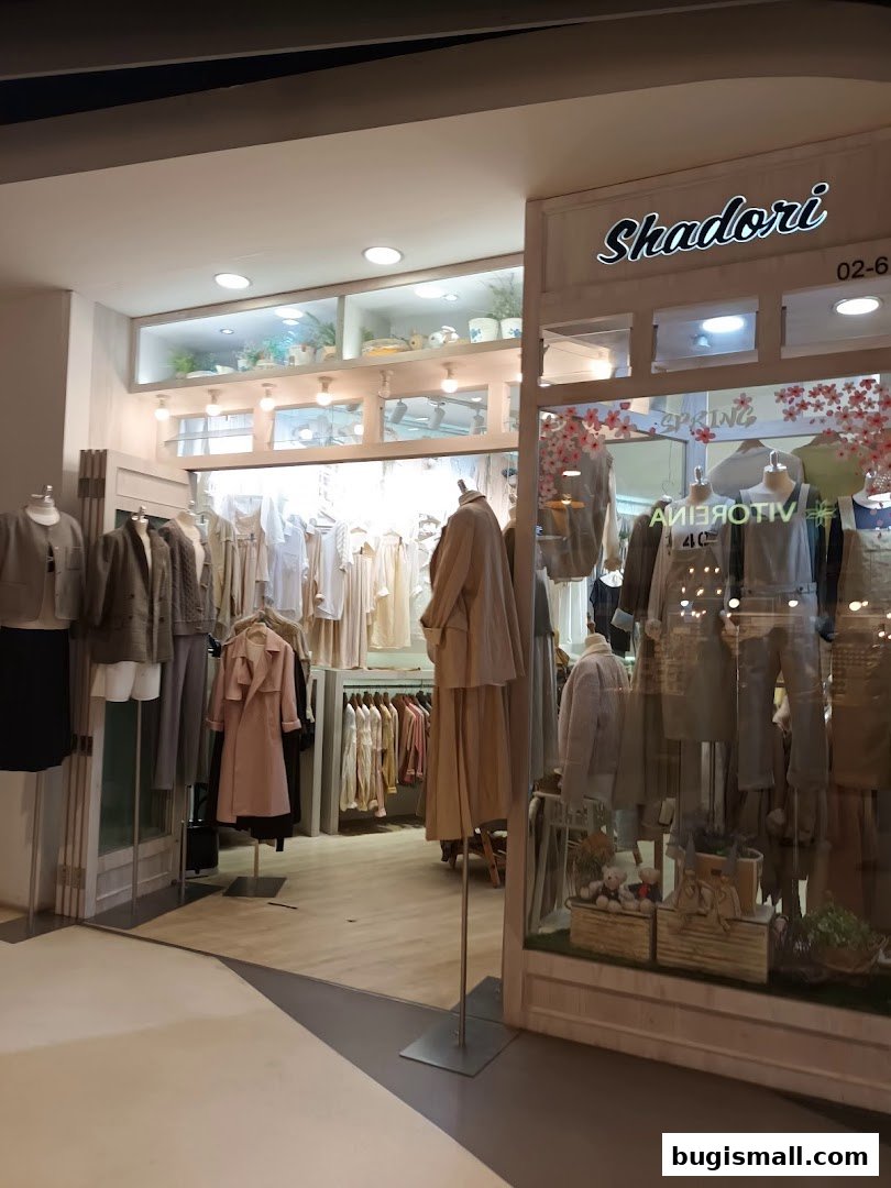 Shadori clothing store entrance with mannequins displaying stylish outfits and a well-lit interior.