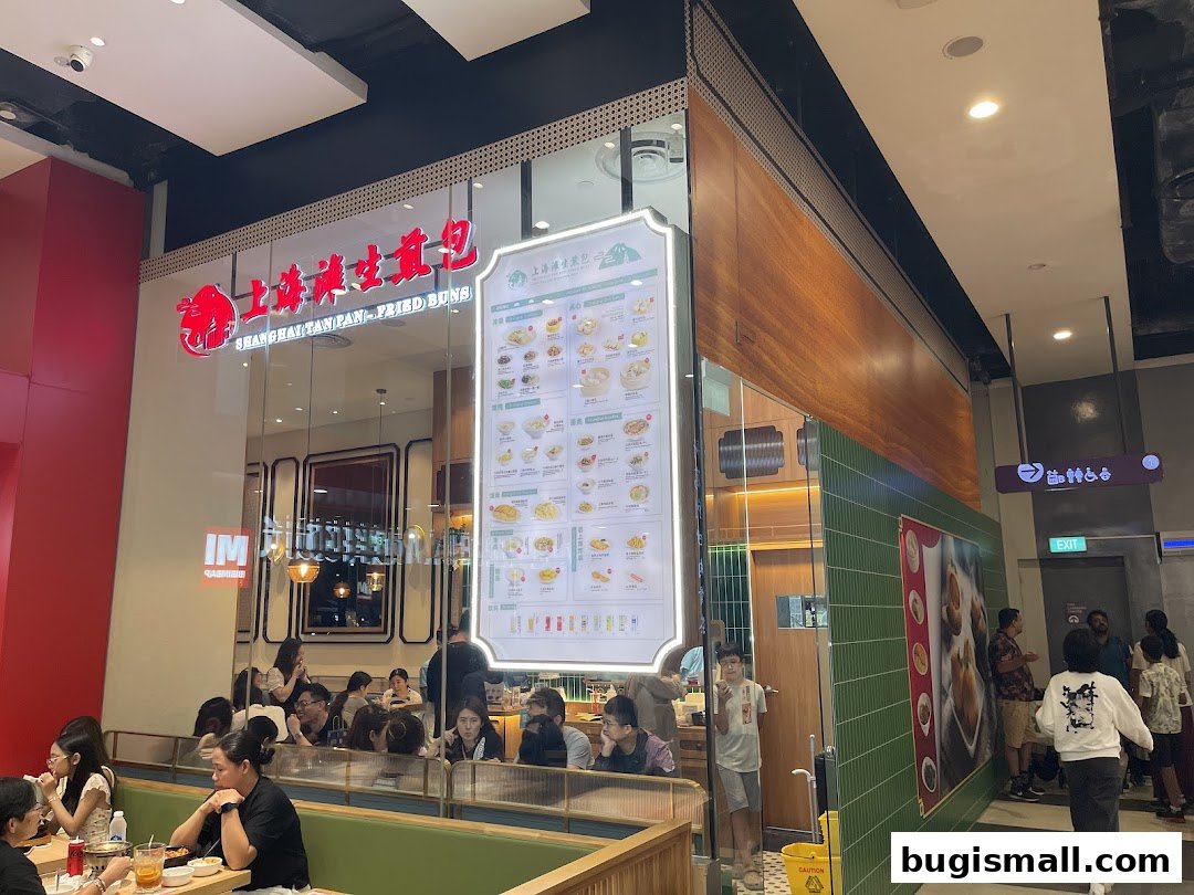 Exterior view of Shanghai Tan Pan-fried Buns restaurant with customers dining inside.