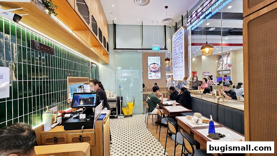 Interior view of Shanghai Tan Pan-fried Buns restaurant with customers dining and staff at the counter.
