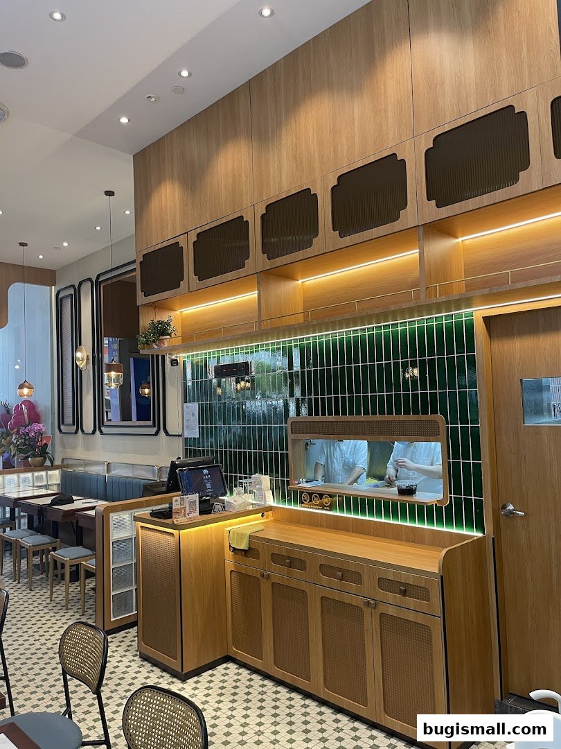 Interior view of a modern restaurant with wooden accents and green tiled walls.