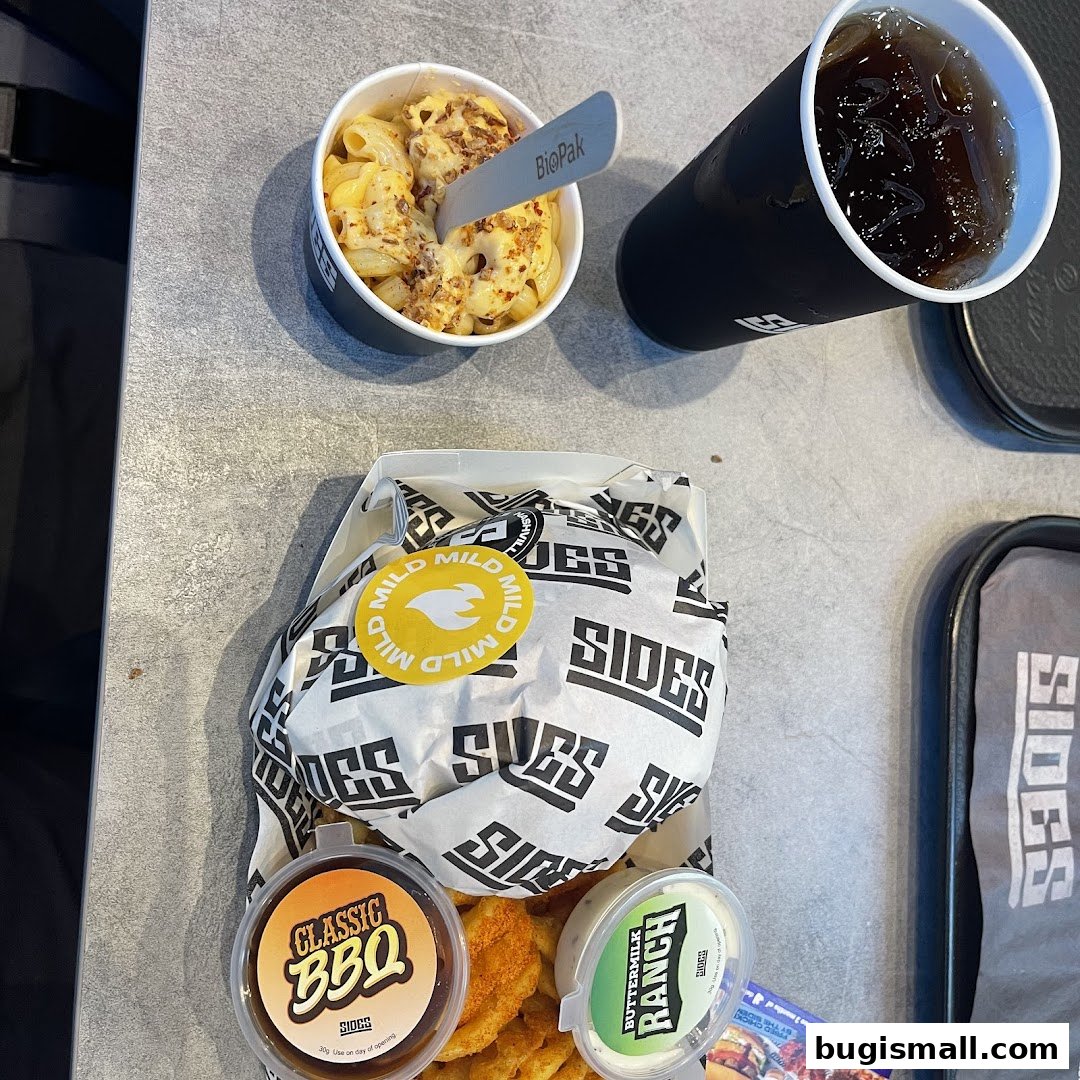 A meal from SIDES featuring a burger, fries, mac and cheese, and a drink.