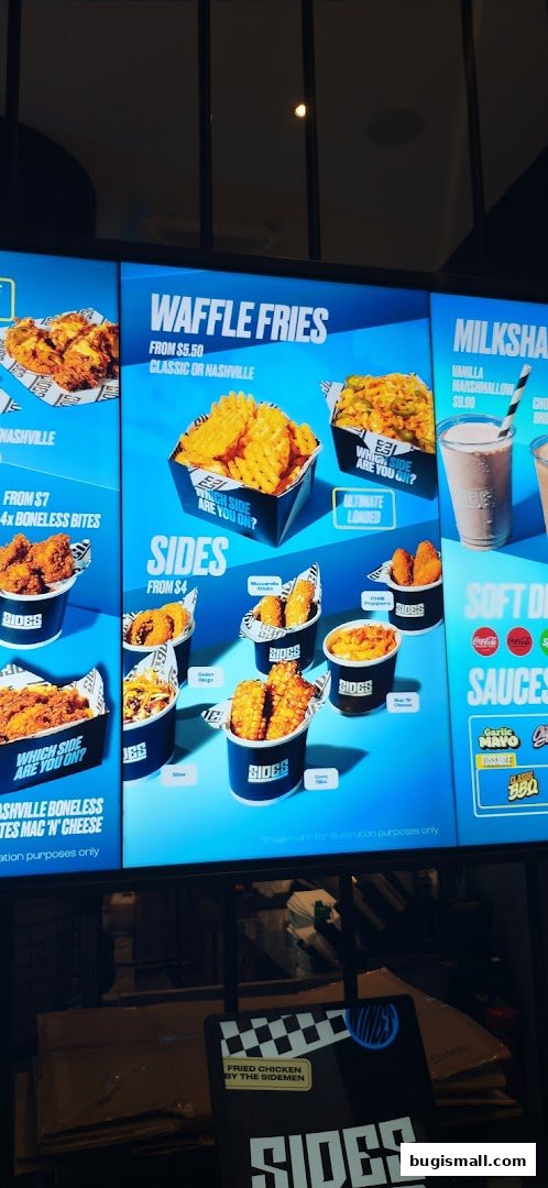 A digital menu board displaying various fried chicken sides and milkshakes.