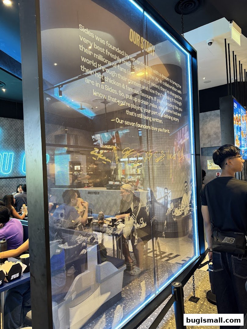 Interior of a restaurant with customers dining and a large glass panel displaying the shop's story.