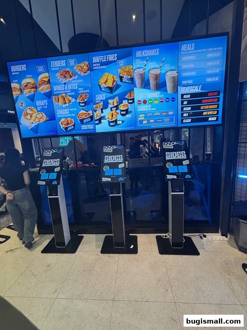 A digital menu board displaying various food items and their prices at SIDES.