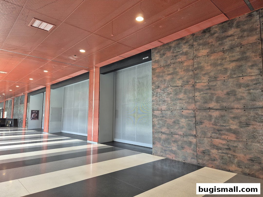 Interior hallway with a distinctive orange perforated ceiling and textured walls.